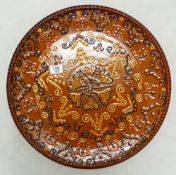 Large terracotta glazed wall plaque with slip ware decoration: diameter 49cm