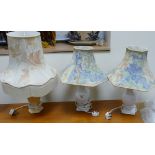 A pair of white ceramic lamp bases with shades: together with a larger similar lamp base and shade