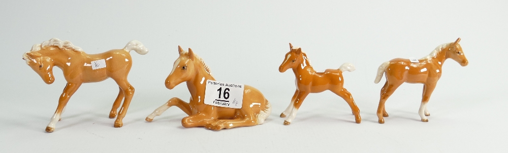 Four Beswick palomino foals: to include lying down, small thoroughbred,