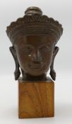 Tibetan bronze buddha head on wood stand: height 21cm.