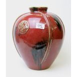A large red glazed vase : with cabochon style motifs. Height 32cm