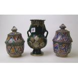 A pair of pottery lidded pots: with hand painted and metal decoration together with a similar twin