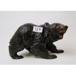 A large black forest carved model of a wooden bear: