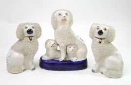A pair of early Staffordshire dogs: together with a similar dog group (3)