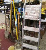 A group of vintage and modern garden tools: forks, rakes, spade, lawn rake, step ladders etc.