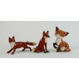 A collection of Beswick foxes: comprising seated comical fox 1733, seated fox 1748 and fox running