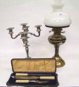 A brass oil lamp with shade and chimney: together with a silver plated candelabra and a cased