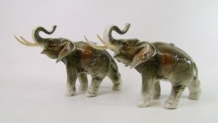 A pair of Royal Dux elephants: with trunks in salute, 15.5cm in height (2).