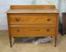 Two drawer oak chest of drawers: raised on turned front supports. 105cm wide x 84cm high x 49cm deep