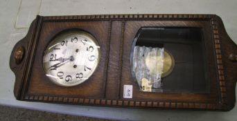 A 1930's oak cased wall clock: with key and pendulum.