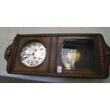 A 1930's oak cased wall clock: with key and pendulum.