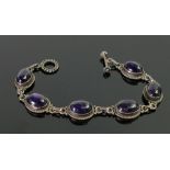 Silver tennis bracelet set with 6 purple gemstones: 24.7g.