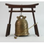 Oriental brass bell on wooden stand: Height of stand 26.5cm