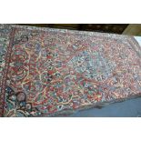 Large tasseled floral decorated rug: tassels missing from one end, 325 x 216cm, distressed in places