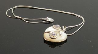 Ornate polished stone heart shaped pendant: and silver necklace.