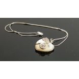 Ornate polished stone heart shaped pendant: and silver necklace.