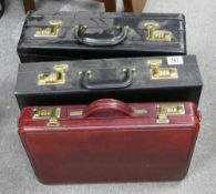 Three briefcases: Two in black and one in burgundy. (3)