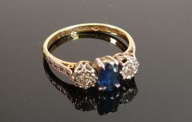 18ct gold & platinum ring: set with central sapphire (7 x 5mm) & diamonds either side (2.5mm),