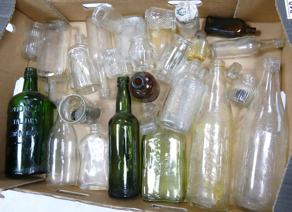 A collection of vinatge glass bottles including: roses Lime Water, Gordons Gin, Woodward Chemists