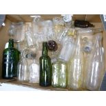A collection of vinatge glass bottles including: roses Lime Water, Gordons Gin, Woodward Chemists
