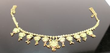 Asian yellow coloured metal ornate necklace: set with red/green stones, tests to 22ct gold or