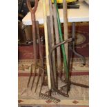 A collection of vintage gardening tools: rakes, fork, lawn shears, bow saw plus bolt cutters etc.