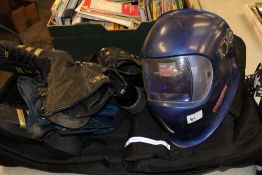 A mixed collection of items: motorbike trousers, welding mask, biker boots etc.