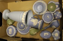 A collection of Wedgwood jasper ware items: bud vases, tankard, lidded boxes, pin dishes, together