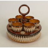 A Doulton Lambeth salt glazed egg stand and egg cups: 6 egg cups, diameter 17cm.