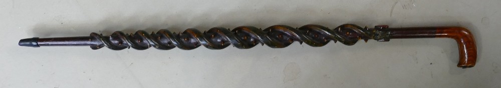 A good 20th century carved twisted wood walking stick: Carved with two serpents, spikes,