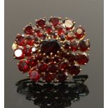 18ct gold garnet set brooch: Gross weight 11.5g, measuring 32mm wide.