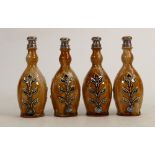 A set of 4 Royal Doulton Lambeth bottles: With silver tops decorated with stylised foliage, height