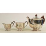 Silver three piece decorative tea set: Hallmarked for Chester 1924, wooden handles to tea pot, 848g.