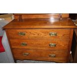 Victorian oak chest of three long drawers: with gallery back raised on castors