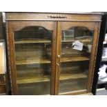 Edwardian glazed oak bookcase: raised on stretched supports. 135cm high x 105cm wide x 32cm deep