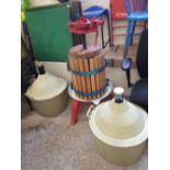 A vintage large wood and metal grape press: together with 2 demijohns.