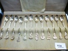 Set of white metal teaspoons each with different flower detailing to handle, stamped HH