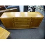 Ercol golden elm sideboard with three central drawers flanked by cupboards