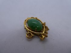 18ct yellow gold pendant with central oval green hardstone, marked 18, on an unmarked yellow metal n