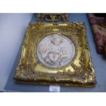 Circular resin plaque depicting cherubs surrounded by square gilt gesso frame, coloured miniature de