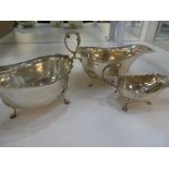 Silver lot of two large gravy boats on three feet, along with a maller gravy boat, the larger hallma