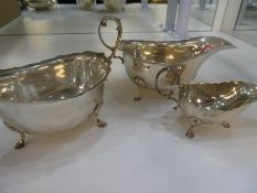 Silver lot of two large gravy boats on three feet, along with a maller gravy boat, the larger hallma