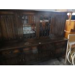 Large oak glazed top sideboard with linen fold panels and leaded glass