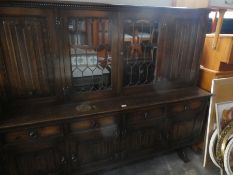 Large oak glazed top sideboard with linen fold panels and leaded glass