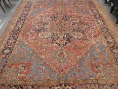 Large middle eastern red ground rug of geometric design with central motif  areas of wear, 129inch x