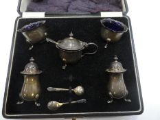 A cased set of silver salts with Bristol blue inserts and salts and peppers. Hallmarked Adie Brother