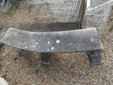 Weathered reconstituted stone curved garden bench supported by 3 plinths