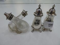 A pair of silver Edwardian salt and pepper, hallmarked Chester 1912, ware to makers mark, on lion fe