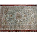 A modern part silk rug having all over floral design, pink bordered 187x 114cms