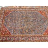 Middle eastern red ground bordered carpet with central blue panel decorated with kingfishers and flo